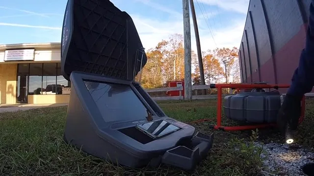 Drain camera control unit and reel set up on grass beside a building