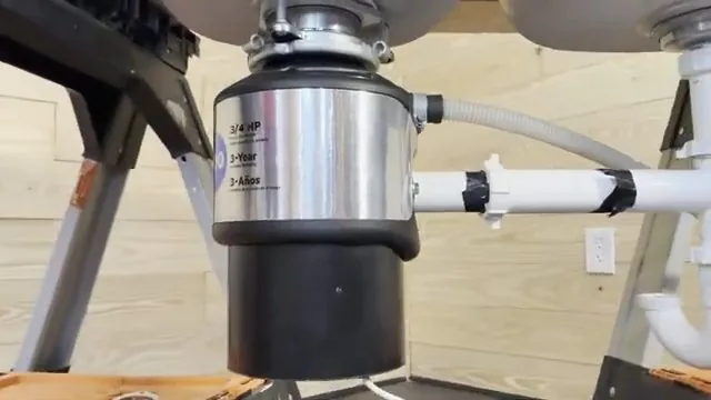 Underside of a sink showing a garbage disposal and its white drain pipes