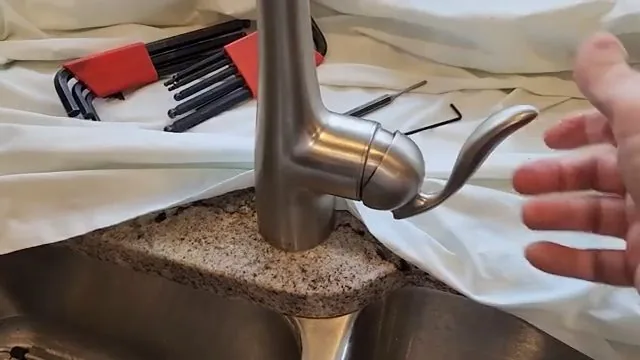 Mixer tap lying on a white towel with a set of hex keys beside it